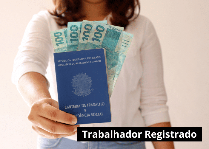 Registro em Carteira mulher segurando carteira de trabalho com dinheiro dentro.